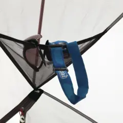 Okulary przeciwsłoneczne i latarka czołowa Petzl wiszą w siatkowej kieszonce namiotu MSR Elixir 2.