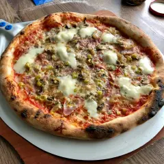 Pyszna pizza na kamieniu, z ciągnącym się serem i chrupiącymi brzegami. Idealny przykład, jak piec pizzę na kamieniu dla najlepszego efektu.