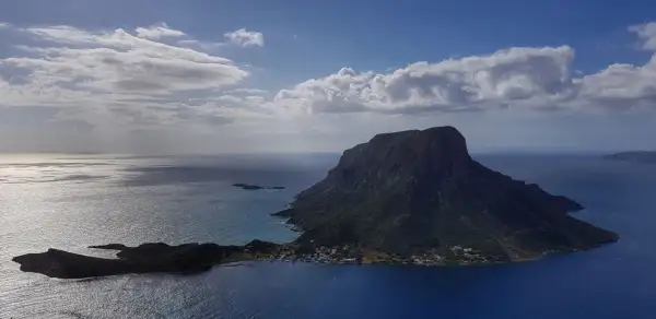 Majestatyczna góra na wyspie Kalymnos, idealna na wspinanie, otoczona błękitnym morzem i chmurami.